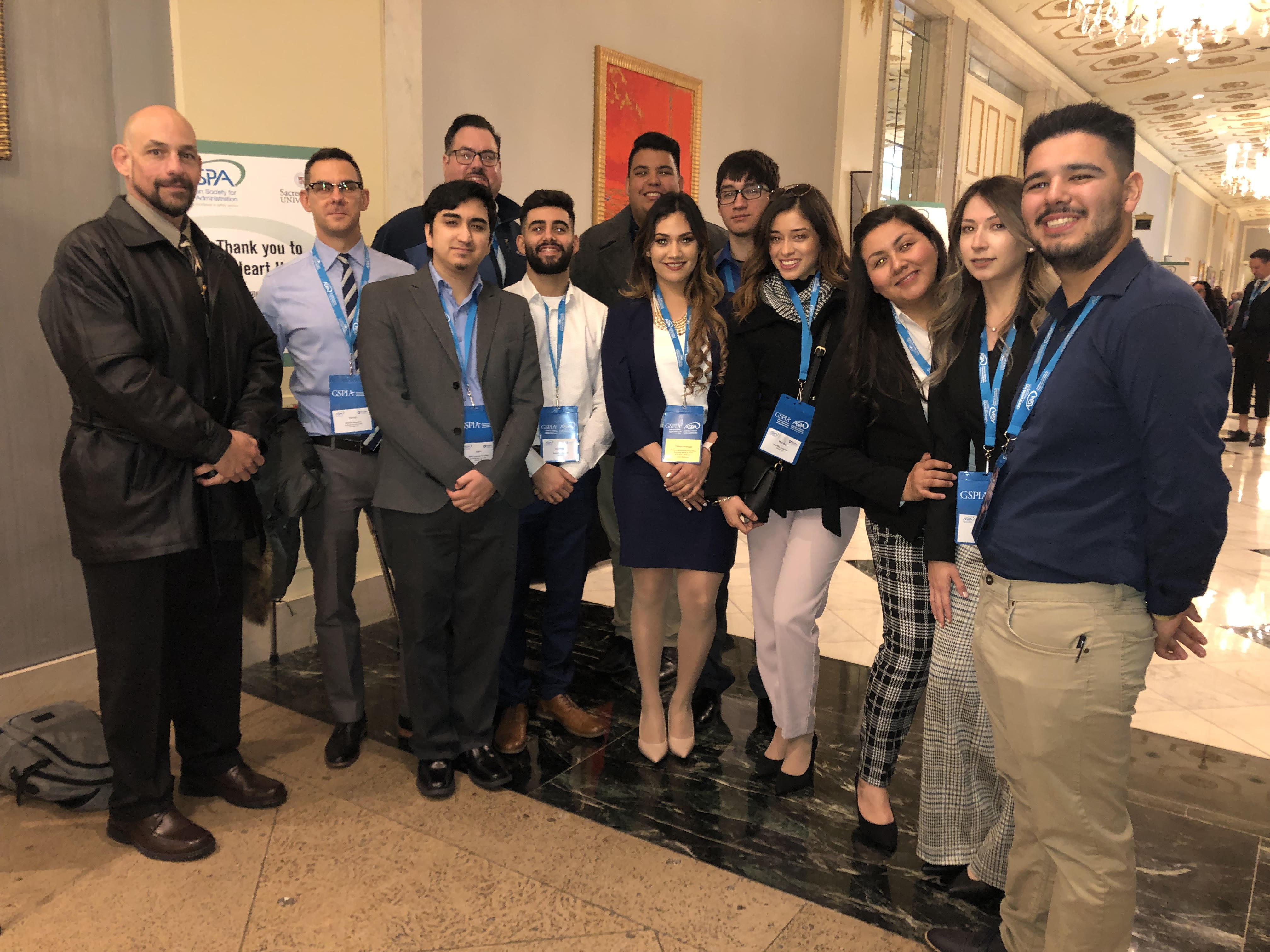 Students and their professors standing in hall looking at camera in ASPA conference